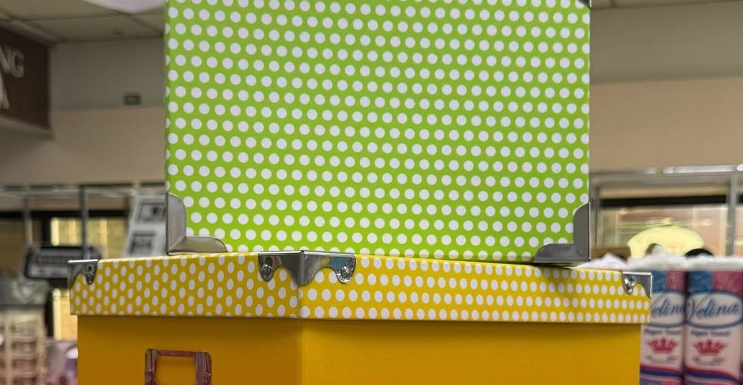 Stack of decorative gift boxes in green, yellow, and patterned designs